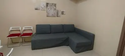 a blue couch in a room with two stools at 1 Bedroom unit near NAIA T3 in Manila