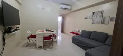 a living room with a couch and a table with chairs at 1 Bedroom unit near NAIA T3 in Manila