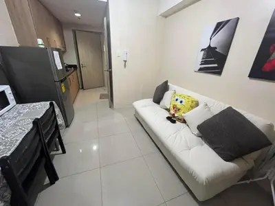 a living room with a white couch and a kitchen at Shore Family Suite 2 Beds WiFi TV Netflix Near MOA 9120 in Manila