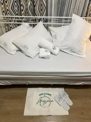 a bed with white pillows and socks on it at Angsana Breeze at Paseo Verde Las Piñas in Manila
