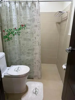 a bathroom with a toilet and a shower curtain at Angsana Breeze at Paseo Verde Las Piñas in Manila