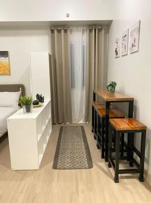 a living room with a bed and two tables in it at SMDC Park Residences near SM City Sta Rosa unit 1 in Ibaba