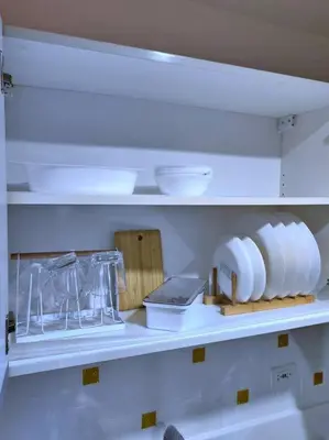 a kitchen shelf with dishes and bowls on it at 1Br FREE parking with balcony near RCBC, Trident, MMC in Manila