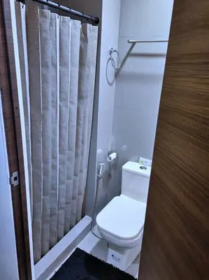 a bathroom with a toilet and a shower curtain at 1Br FREE parking with balcony near RCBC, Trident, MMC in Manila