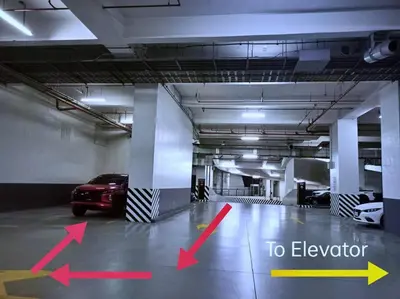 a car parked in a garage with arrows pointing to elevator at 1Br FREE parking with balcony near RCBC, Trident, MMC in Manila