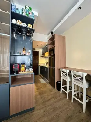 a kitchen with a counter and a bar with stools at Cozy Unit Right by the Pool with Massage in Silang