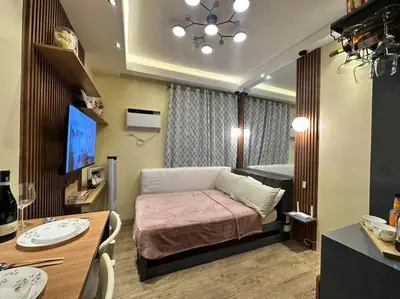 a small bedroom with a bed and a table at Cozy Unit Right by the Pool with Massage in Silang