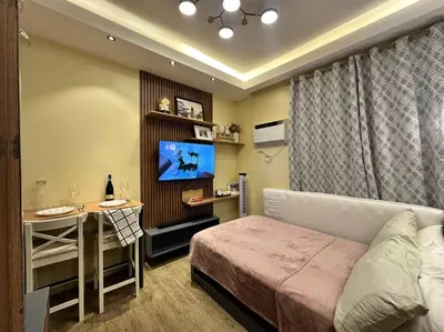 a bedroom with a bed and a desk and a television at Cozy Unit Right by the Pool with Massage in Silang
