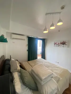 a bedroom with a large bed with pillows on it at Raya Garden Vacation Home 2 bedroom sunset view in Manila