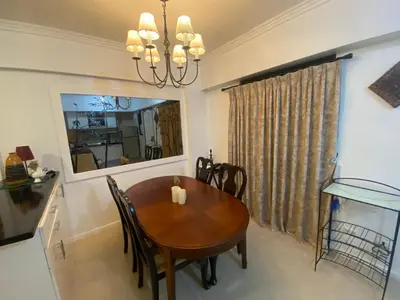a dining room with a wooden table and a fish tank at Raya Garden Vacation Home 2 bedroom sunset view in Manila
