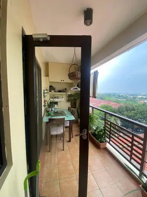 a kitchen and dining room with a view of a balcony at Raya Garden Vacation Home 2 bedroom sunset view in Manila