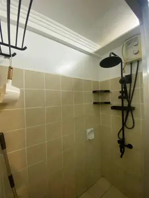 a bathroom with a shower with a light on the ceiling at Raya Garden Vacation Home 2 bedroom sunset view in Manila