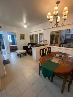 a living room with a table and a couch at Raya Garden Vacation Home 2 bedroom sunset view in Manila