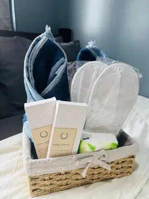 a basket filled with towels on a bed at Affordable Staycation At Sea Residence Near Moa By Dona Flores in Manila