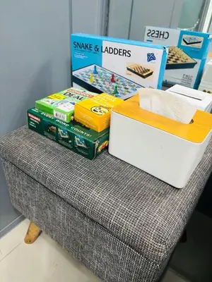 a table with a stack of books and a box at Affordable Staycation At Sea Residence Near Moa By Dona Flores in Manila