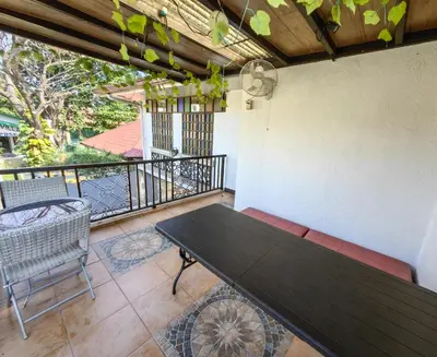 a patio with a table and chairs on a balcony at Cozy Las Pinas Haven with Big Garden, Pet Friendly - Near Super Market and the Airport in Manila