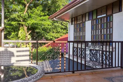 a balcony with a bench and a building at Cozy Las Pinas Haven with Big Garden, Pet Friendly - Near Super Market and the Airport in Manila