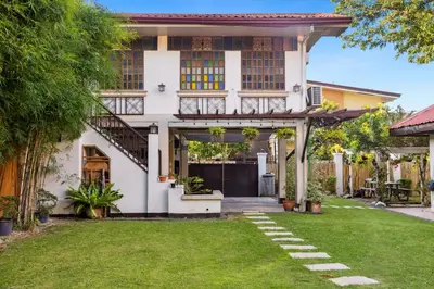 a white house with a lawn in front of it at Cozy Las Pinas Haven with Big Garden, Pet Friendly - Near Super Market and the Airport in Manila