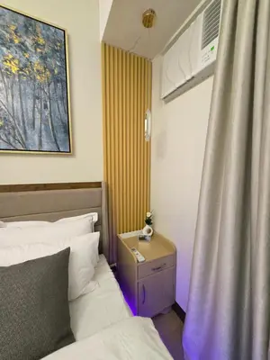 a bedroom with a bed and a nightstand and a window at Cozy 2BR 2BA 2 Balconies Manhattan Heights Cubao in Manila