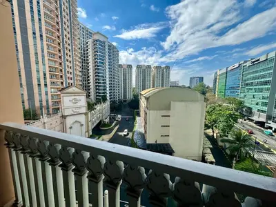 a balcony with a clock tower and a city at King Bed, Washer, Air Dry, Sauna, Gym & Pool Access, FAST Wi-Fi, Elegant Studio, Near Venice Grand Canal Mall, Walking Distance Britsh Embassy, 5 min drive to BGC, 10 min drive to Manila Airport NAIA 3 in Manila