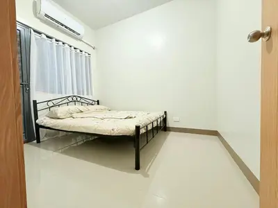 a bed in a white room with a window at SMDC Bloom residence Sucat Stunning 2BR in Manila