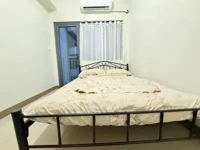 a small bed in a room with a window at SMDC Bloom residence Sucat Stunning 2BR in Manila