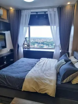 a bedroom with a bed with a large window at South Residences, Las Piñas in Manila