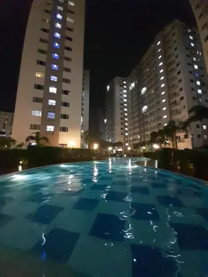 a large swimming pool in a city at night at South Residences, Las Piñas in Manila
