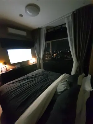 a bedroom with a large bed with a window at South Residences, Las Piñas in Manila