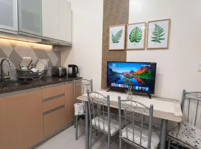 a kitchen with a table with a computer on it at Heart of BGC in Manila