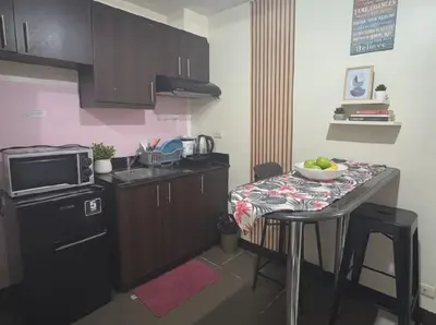 a kitchen with a table with a bowl of fruit on it at Heart of BGC in Manila