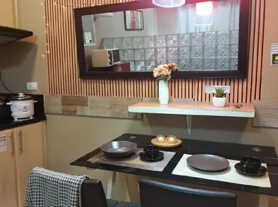a kitchen with a counter with a vase of flowers at Cozy Home in BGC in Manila