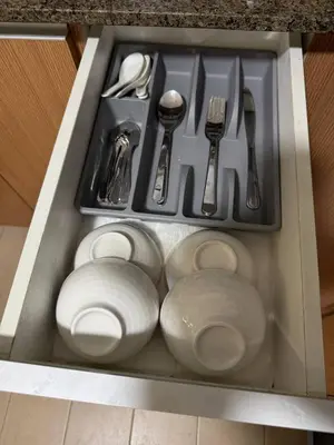 a drawer filled with white plates and utensils at Condotel near NAIA T3 Airport in Manila