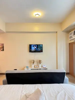 a bedroom with a bed and a tv on the wall at Condotel near NAIA T3 Airport in Manila
