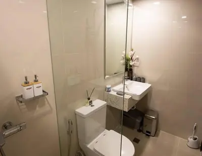 a bathroom with a toilet and a sink and a shower at The Room of Requirement in Manila