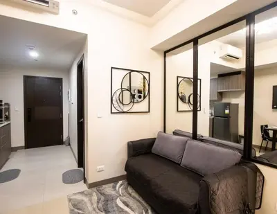 a living room with a couch and a mirror at The Room of Requirement in Manila