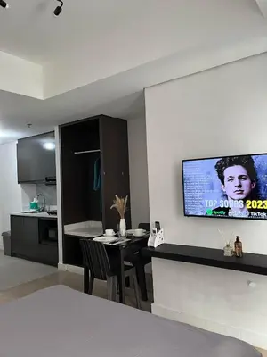 a living room with a table and a tv on the wall at Condotel 1 Bedroom Across SM Aura in Manila