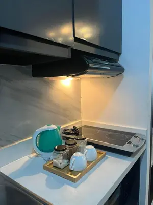 a kitchen with a stove and a tray with pots and pans at Condotel 1 Bedroom Across SM Aura in Manila
