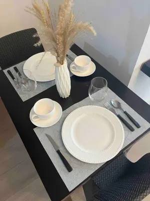 a black table with white plates and silverware on it at Condotel 1 Bedroom Across SM Aura in Manila