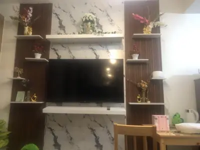 a living room with a large television on a wall at TresMaria'Staycation in Manila