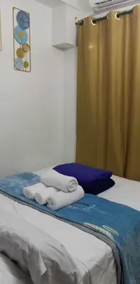 a room with a bed with towels on it at TresMaria'Staycation in Manila