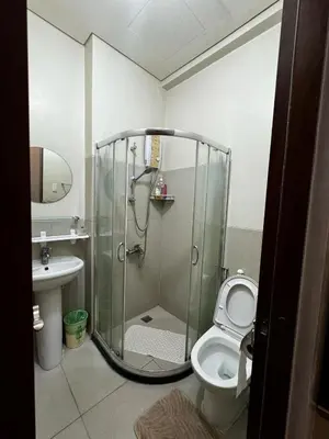 a bathroom with a shower and a toilet at Sophia's Place Beacon Amorsolo in Manila