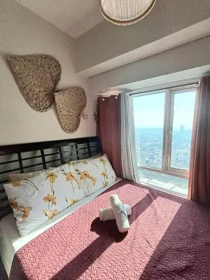 a bedroom with a bed with a teddy bear on it at Sophia's Place Beacon Amorsolo in Manila