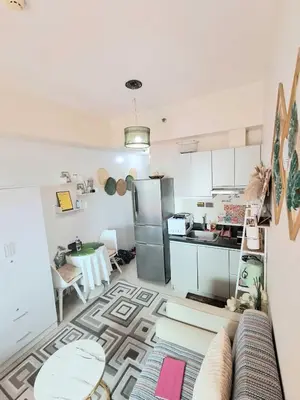 a kitchen with a refrigerator and a table at Sophia's Place Beacon Amorsolo in Manila