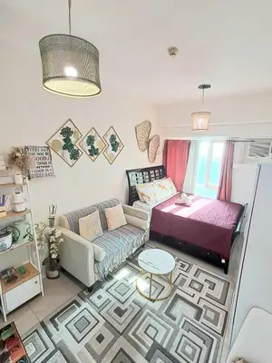 a living room with a bed and a couch at Sophia's Place Beacon Amorsolo in Manila