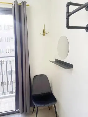 a chair sitting next to a window with a mirror at 19106 Condotel at Shore 2 MOA wNetflix in Manila