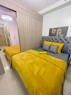 two beds in a room with yellow sheets at 19106 Condotel at Shore 2 MOA wNetflix in Manila