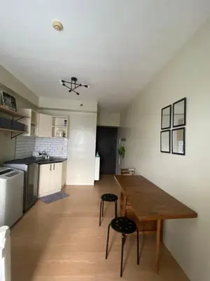 a kitchen and dining room with a wooden table and chairs at Condo near ATC- Molito Alabang, Muntinlupa in Manila