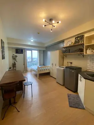 a kitchen and living room with a table and a dining room at Condo near ATC- Molito Alabang, Muntinlupa in Manila