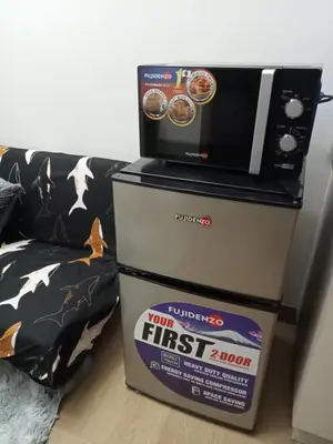 a microwave on top of a box next to a couch at SM HOME Spring Residences Staycation and Condotel in Manila